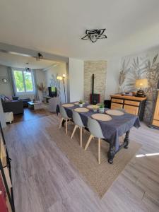 a dining room with a table and a living room at Gite piscine privée climatisation in Célon