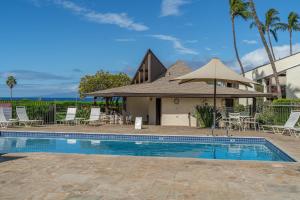 a swimming pool with chairs and a house at Conveniently located two bedroom two bath HK319 in Wailea