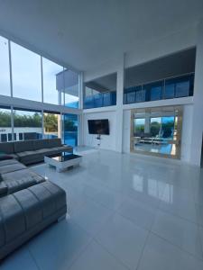 a large white living room with a couch and a tv at Finca Villa Sonada in Darién