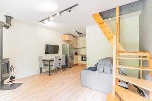a living room with a loft bed and a kitchen at Cute house in Kretowiny