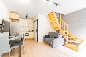a living room with a staircase and a kitchen at Cute house in Kretowiny
