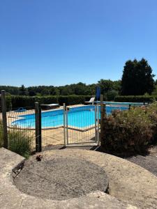 a gate in front of a swimming pool at La Grange aux coccinelles in Saint-Martin-des-Fontaines +12 photos