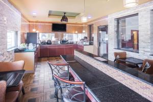 a kitchen with a bar with chairs and a counter top at Super 8 by Wyndham Van Buren/Ft. Smith Area in Van Buren