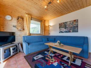 a living room with a blue couch and a table at Chapter Two in Niedernsill