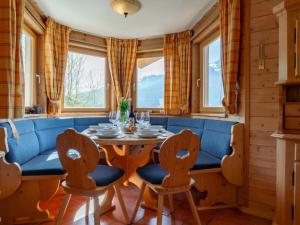 a dining room with a blue couch and a table and chairs at Chapter Two in Niedernsill