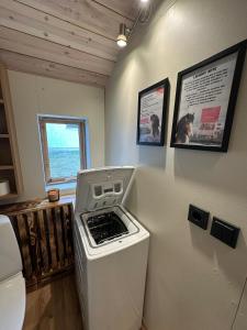 a laundry room with a stove and a window at Hoofprints Farm stay in Fludir +6 photos