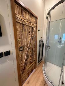 a wooden door in a bathroom with a shower at Hoofprints Farm stay in Fludir