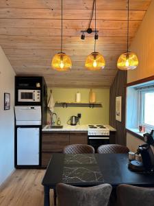 a kitchen with a table and some lights at Hoofprints Farm stay in Fludir