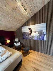 a bedroom with a bed and a tv on a wall at Hoofprints Farm stay in Fludir