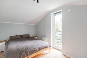 a bedroom with a bed and a large window at Cute house in Kretowiny