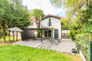 a house with a patio and an umbrella at Cute house in Kretowiny