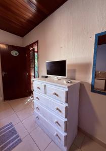 a dresser with a television on top of it at Pousada bella mar buzios in Búzios