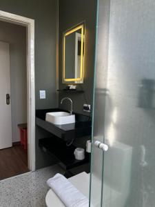 a bathroom with a sink and a mirror at Hotel Porto Di Mare in Ubatuba