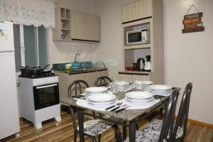 a kitchen with a table with plates on it at Casa com estacionamento no centro de Concórdia SC in Concordia