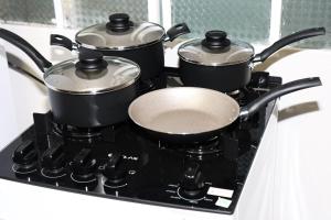 a group of pots and pans on a stove at Casa com estacionamento no centro de Concórdia SC in Concordia