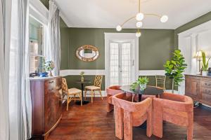 a dining room with green walls and a table and chairs at Southern Wind Inn in St. Augustine