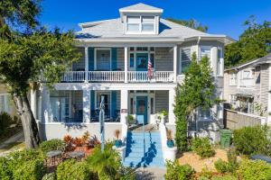 a white house with blue doors and a porch at Southern Wind Inn in St. Augustine