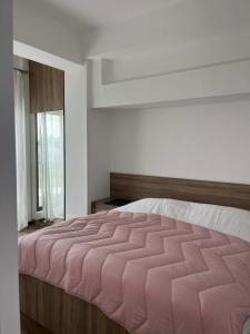 a bedroom with a large bed with a pink comforter at TelaValley Residence in Shalauri +14 photos