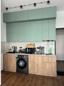 a kitchen with blue cabinets and a washing machine at TelaValley Residence in Shalauri