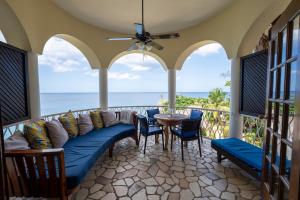 a porch with a blue couch and a table and chairs at Catcha Falling Star in Negril