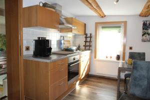 a kitchen with wooden cabinets and a stove top oven at Ferienwohnung-Brenda in Wolfshagen