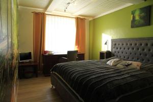 a bedroom with a bed and a desk and a window at Ferienwohnung-Brenda in Wolfshagen