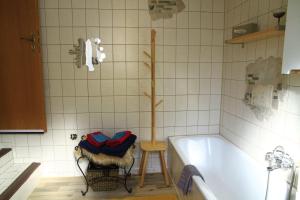 a bathroom with a tub and a chair next to it at Ferienwohnung-Brenda in Wolfshagen +42 photos