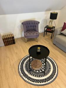 a living room with a chair and a coffee table at Gîte Centre Chatillon 130m2 Parking prive La Maison d Hyppolite in Châtillon-sur-Seine +18 photos
