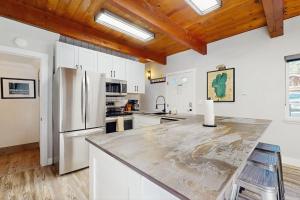 a kitchen with white cabinets and a stainless steel refrigerator at Speckled Tahoe in Kings Beach