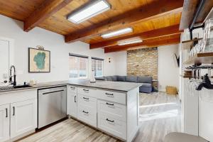 a kitchen with white cabinets and wooden ceilings at Speckled Tahoe in Kings Beach