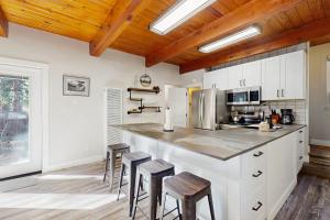 a kitchen with white cabinets and a counter with stools at Speckled Tahoe in Kings Beach +9 photos