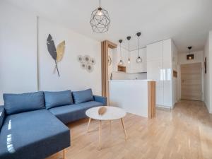a living room with a blue couch and a kitchen at Becici Chic 1BR Condo swimming pool long term in Budva