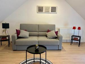 a living room with a couch and a table at Gîte Centre Chatillon 130m2 Parking prive La Maison d Hyppolite in Châtillon-sur-Seine