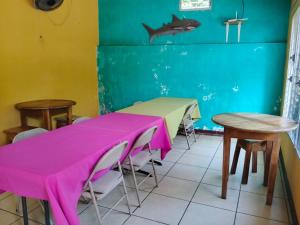 a dining room with tables and a shark on the wall at Miraflores Beach Lodge in Santo Domingo