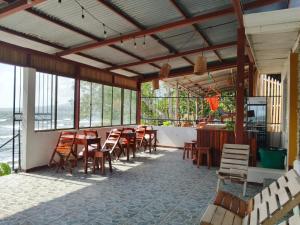 a restaurant with wooden tables and chairs and windows at Miraflores Beach Lodge in Santo Domingo