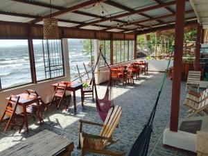 a restaurant with tables and chairs and a swing at Miraflores Beach Lodge in Santo Domingo