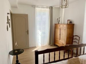 a room with a bed and a wooden cabinet and a window at Gîte Centre Chatillon 130m2 Parking prive La Maison d Hyppolite in Châtillon-sur-Seine