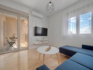 a living room with a blue couch and a table at Becici Chic 1BR Condo swimming pool long term in Budva