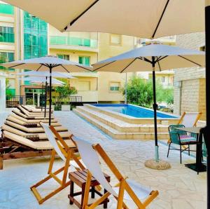 a group of chairs and umbrellas next to a pool at Becici Chic 1BR Condo swimming pool long term in Budva
