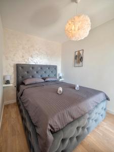 a bedroom with a large bed with a gray bedspread at Becici Chic 1BR Condo swimming pool long term in Budva +6 photos