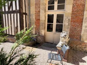 a pair of chairs sitting in front of a door at Le Douet Fleury - Chambre d'Hôtes et Gîtes in Livarot