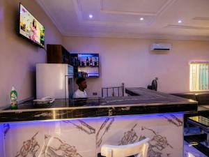 a man sitting at a counter in a bar at The Whale Inn Narayi rd Barnawa high cost in Kaduna +18 photos