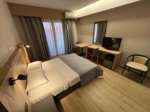 a hotel room with a bed and a desk with a computer at Achillio Hotel in Komotini
