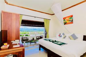 a bedroom with a bed and a desk and a window at Luang Prabang View Hotel in Luang Prabang