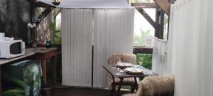 a balcony with a table and chairs and a curtain at Chalé Hidro Jurerê in Florianópolis