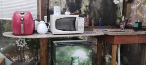 a kitchen counter with a microwave and a blender at Chalé Hidro Jurerê in Florianópolis