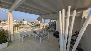 a patio with a table and chairs on a balcony at Arneo Terra del Sole B&B in Torre Lapillo