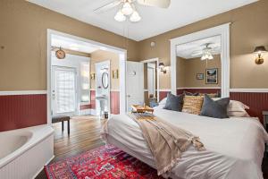 a bedroom with a large bed and a bath tub at Southern Wind Inn in St. Augustine
