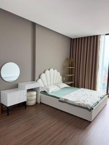 a bedroom with a bed and a chair and a mirror at BRG Premium Apartments in Hai Phong