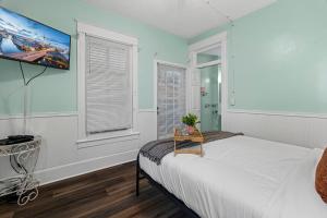 a bedroom with a bed and a tv on the wall at Southern Wind Inn in St. Augustine